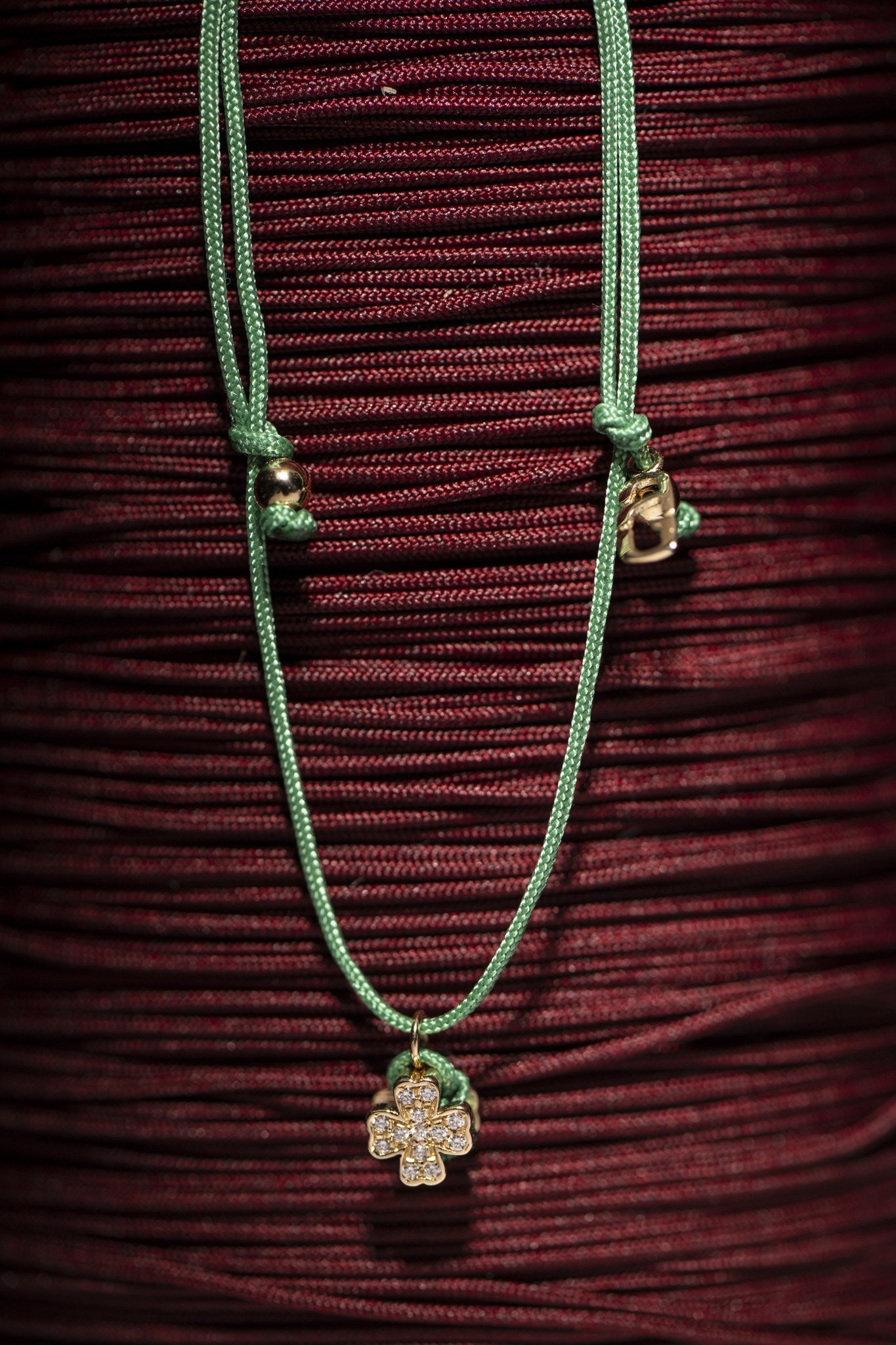 Concordia four-leaf clover bracelet styled on red cord skein