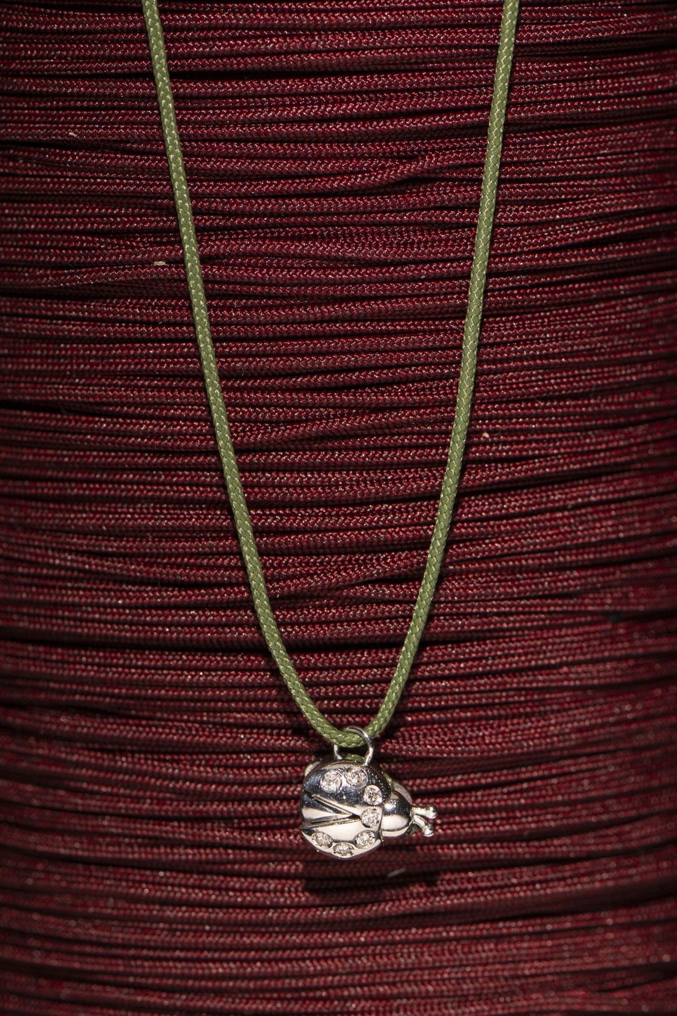 Concordia ladybird charm styled on red cord skein